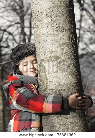 Boy Hugging A Tree, Listening The Sounds Of The Nature. Taking Care Of The Forest.