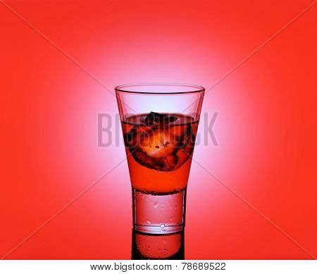 Short Drink Glass With Red Liquid And Ice Cubes