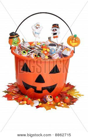 Kinder-Halloween-Kürbis Eimer mit Süßigkeiten und Herbstblätter