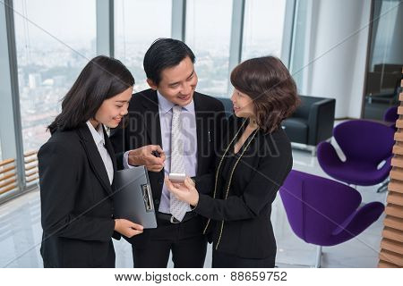 Showing Smartphone To Colleagues