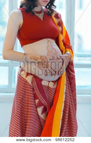The pregnant woman belly with henna tattoo