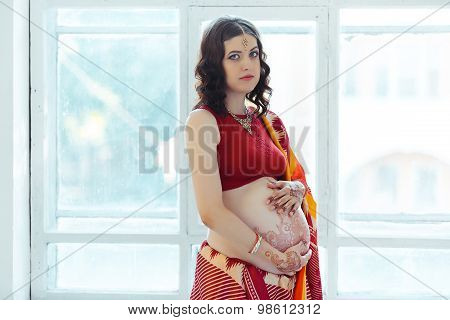 The pregnant woman belly with henna tattoo
