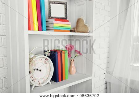 Books and decor on shelves in cupboard