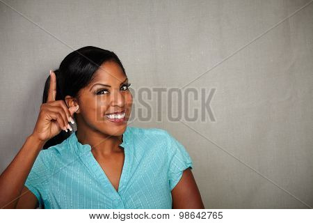 Charismatic Woman Pointing Up While Smiling