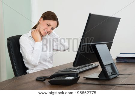 Businesswoman Suffering From Neckache At Desk