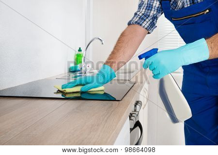 Worker Cleaning Electric Hob