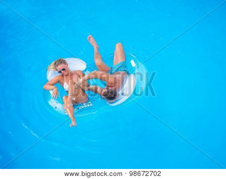 Couple Outside Relaxing In Swimming Pool in the summertime