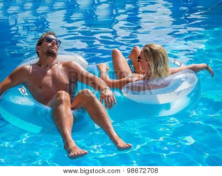 Couple Outside Relaxing In Swimming Pool in the summertime