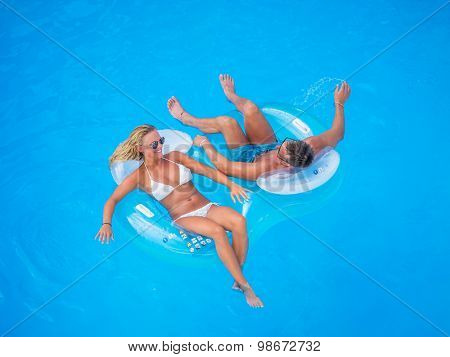 Couple Outside Relaxing In Swimming Pool in the summertime