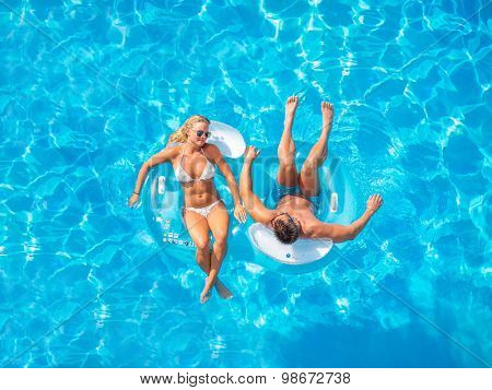 Couple Outside Relaxing In Swimming Pool in the summertime