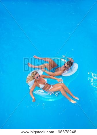 Couple Outside Relaxing In Swimming Pool in the summertime