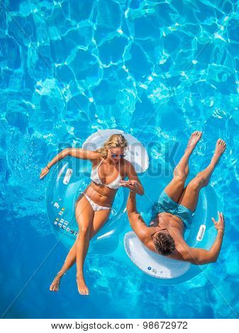 Couple Outside Relaxing In Swimming Pool in the summertime