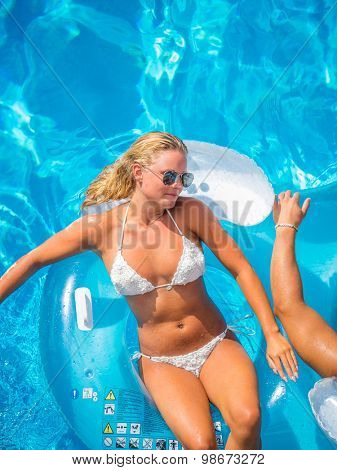Couple Outside Relaxing In Swimming Pool in the summertime