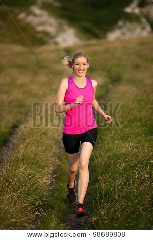Beautiful Young Woman Runns Cross Country On A Mountian Path At Sunrise