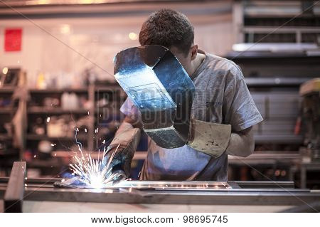 Employee welding using MIG/MAG welder.