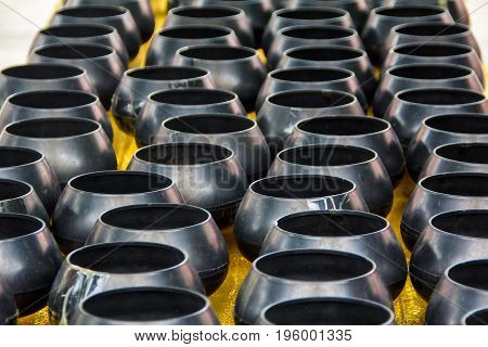 Black monk's alms bowls on table in temple waiting for donation at Wat Maha Wanaram (Wat Pa Yai)Ubonratchathani ProvinceThailand.