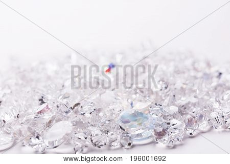 Shiny glass beads on white background, one sparkling crystal. Jewelry, craft, bijouterie concept