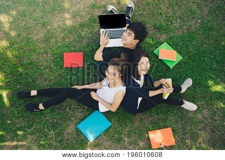 Young Students Group Smiling with Folders Book and Laptop computer Smiling on Grass in Education Campus University Top view