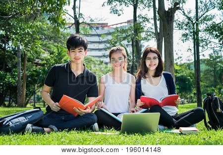 Young Student Asian Group Teenager with school folders on grass at university campus college