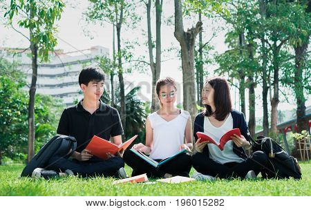 Young Student Asian Group Teenager with school folders on grass at university campus college