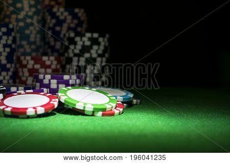 Stack of Poker chips on a green gaming poker table at the casino. Poker game concept. Playing a game with dice. Casino Concept for business risk chance good luck or gambling. chips for poker game