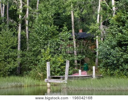 Pier and wooden house in forest on Finnish lake