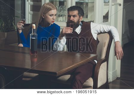 Man And Girl Sharing Bottle Of Red Wine In Restaurant