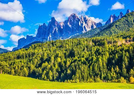 Warm autumn in the Dolomites, the Val de Funes. The valley is surrounded by a dentate wall of dolomite rocks. The concept of ecological tourism