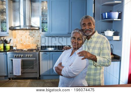 Portrait of senior couple standing in kitchen at home