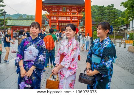 KYOTO JAPAN - NOVEMBER 24, 2016: Young women visiting a fushimi inari temple at rainy day in Kyoto, Japan.
