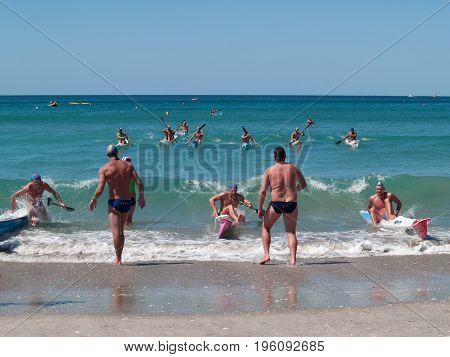 Mount Maunganui, New Zealand - January 28, 2012; Men involved in canoe racing paddling through surf in competitions at Mount Maunganui Surf Lifesaving 2012.