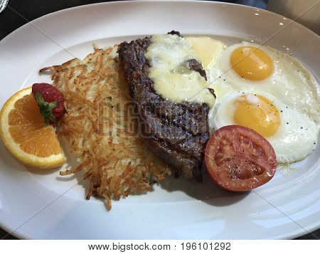 Steak and eggs with hashbrown. A hearty breakfast.