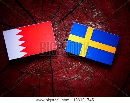 Bahraini Flag With Swedish Flag On A Tree Stump Isolated