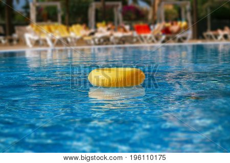 floating ring on blue water swimpool with waves reflecting in the summer sun