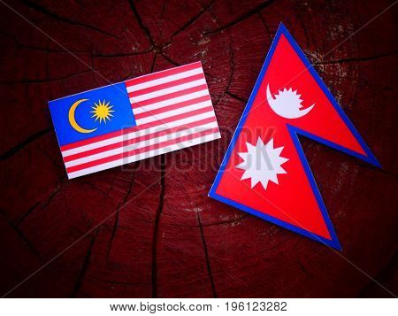 Malaysian Flag With Nepali Flag On A Tree Stump Isolated