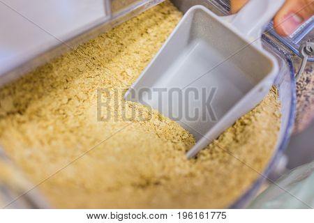 Person Scooping Nutritional Yeast From Bulk Section