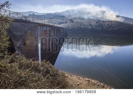 La Pesga bridge over Gabriel y Galan Reservoir waters Caceres Spain. Car crossing the bridge.