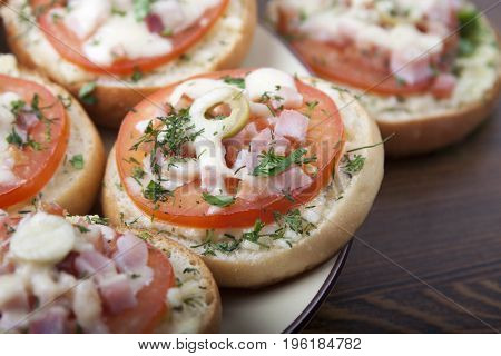 Mini pizza on ready-made buns with tomatoes and sausage