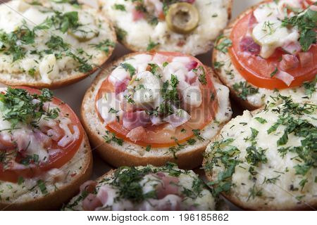 Mini pizza on ready-made buns with tomatoes and sausage