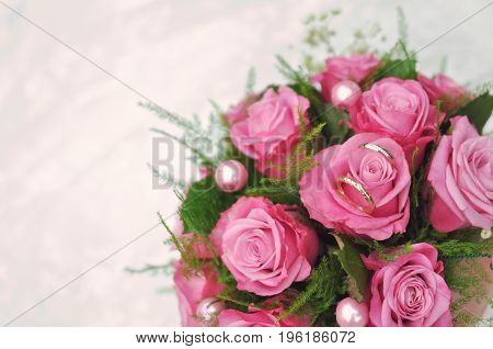 Wedding bouquet of pink roses lying on white floor