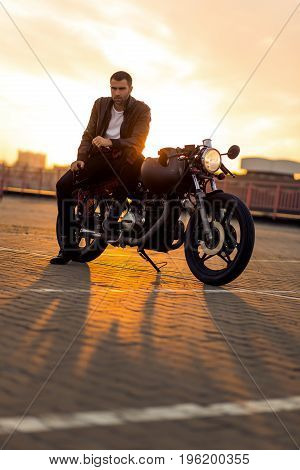 Brutal Man Sit On Cafe Racer Custom Motorbike.