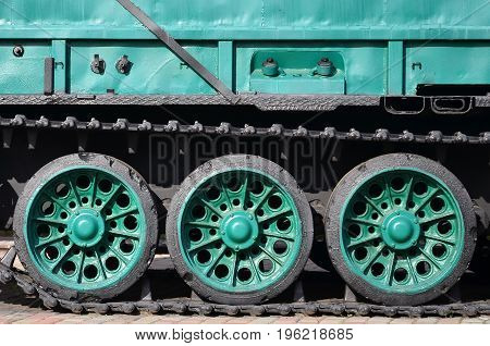 Side View Of The Vehicle On A Caterpillar Track With Black Tracks And Green Wheels And A Side Metal