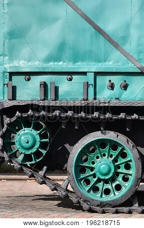 Side View Of The Vehicle On A Caterpillar Track With Black Tracks And Green Wheels And A Side Metal