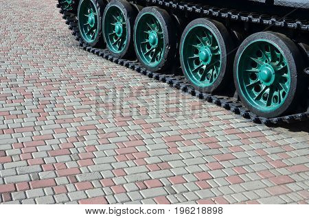 A Military Vehicle On Caterpillar Tracks Stands On A Square Of Paving Stones. Photo Of Green Caterpi