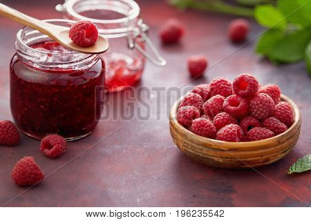 Fresh raspberries and a jar of raspberry jam. 