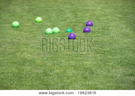Bolas de petanca azul y verde en pasto verde cortado