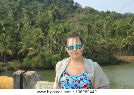 Beautuful girl posing on the brige near tropical forest