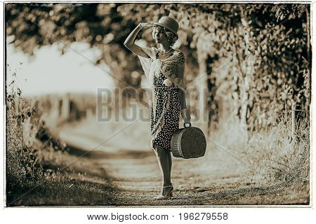 Classic Black And White Photo Of 1920S Fashion Woman Standing With Handbag On Rural Pathway.