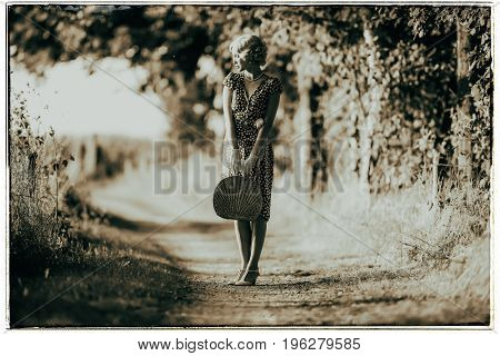 Classic Black And White Photo Of 1920S Fashion Woman Standing With Handbag On Rural Pathway.