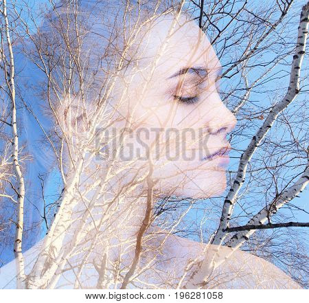 Double exposure portrait of beautiful woman combined with photograph of tree.